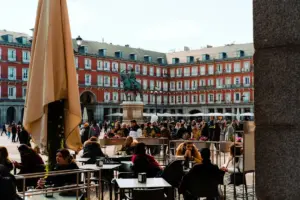 a group of people sitting at tables in a courtyard
