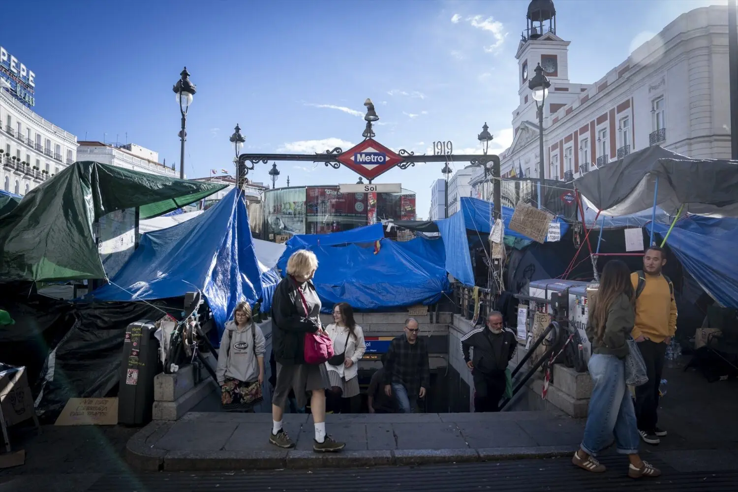 Uno de los accesos a la esstación de Metro de Sol con la acampada alrededor Uno de los accesos a la esstación de Metro de Sol con la acampada alrededor
