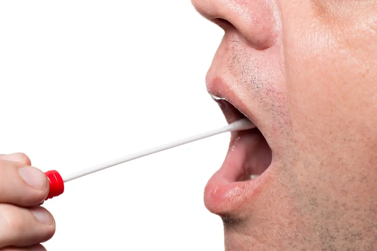 muestra de saliva Un sanitario obtiene una muestra de saliva