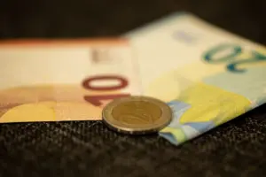Primer plano detallado de billetes y monedas en Euros, mostrando la semejanza de la moneda europea.