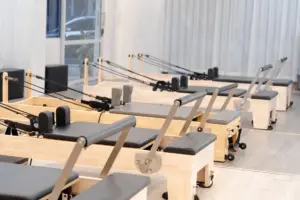 Un estudio contemporáneo de Pilates equipado con múltiples reformadores de madera para el entrenamiento físico.