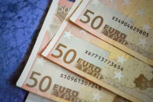 Montón de billetes de 50 Euros dispuestos sobre una superficie texturizada, enfatizando la moneda europea.